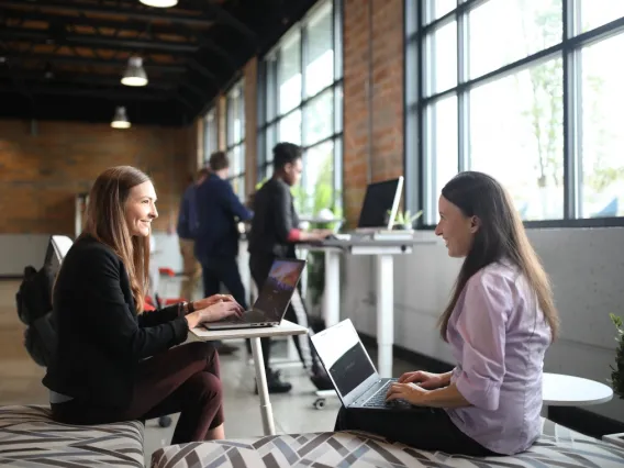 two women on laptops conversing